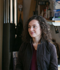 A woman sits in a sunny studio